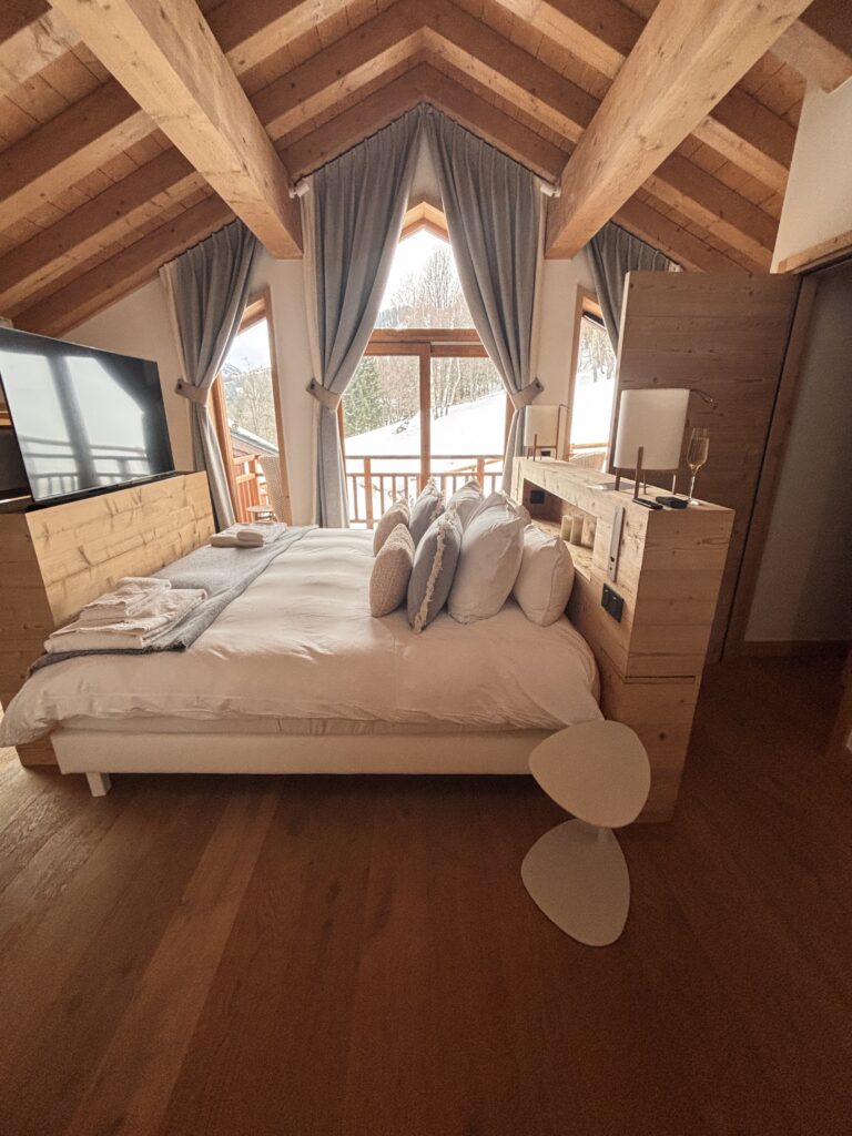 A master bedroom with a hidden TV and stunning views in French Alps chalet